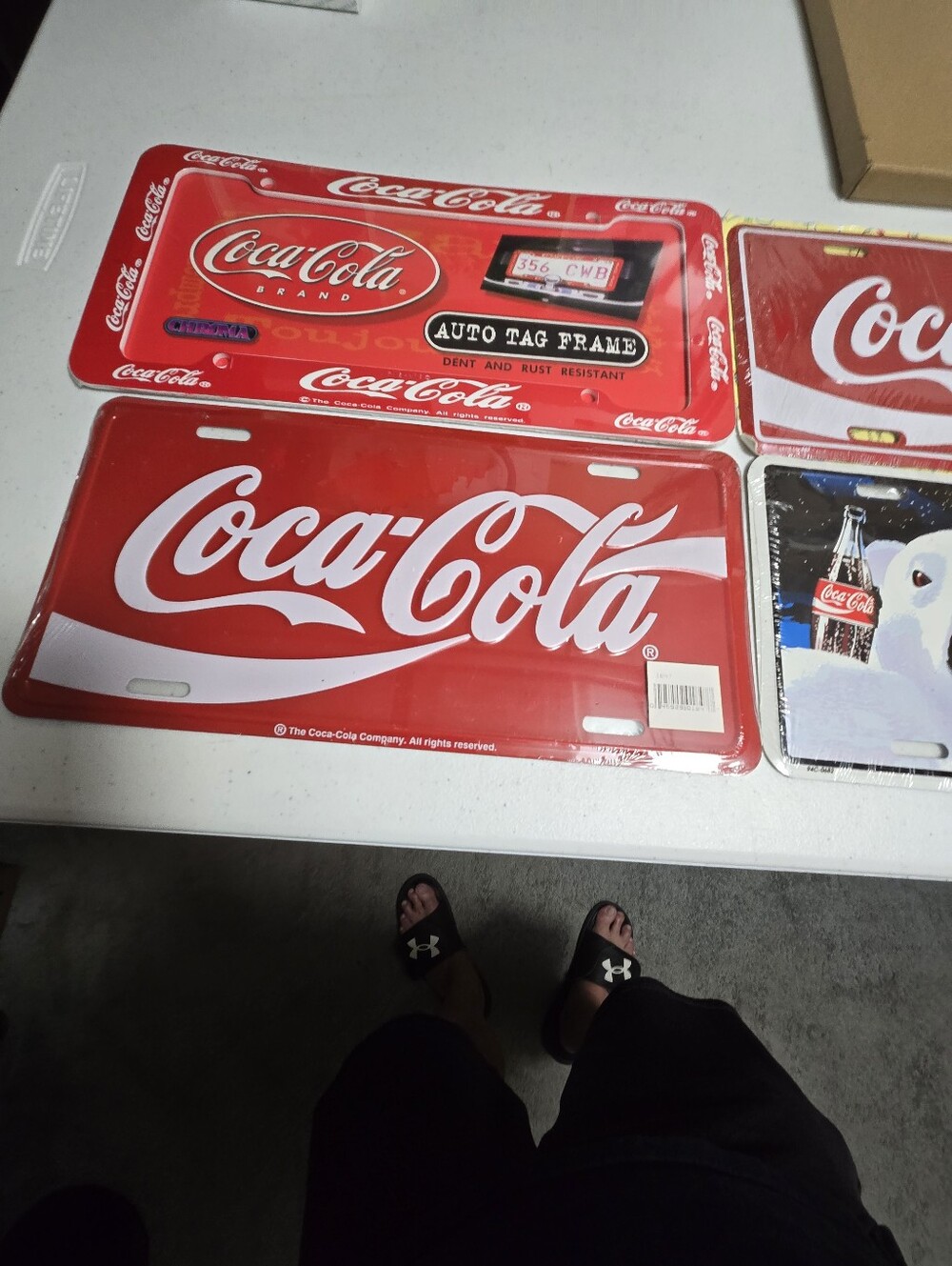 3 Coke License Plates. 1 Coke License Plate Frame. All New Original Packaging